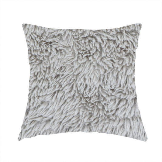 The fabric used to create this handmade cushion is a cool-toned, light silver-grey high-pile faux fur fabric. It has a dense, plush texture characterized by soft, tousled fibres that create a cosy, shag-like appearance.