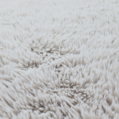 A cool-toned, light silver-grey high-pile faux fur fabric. It has a dense, plush texture characterized by soft, tousled fibres that create a cosy, shag-like appearance.