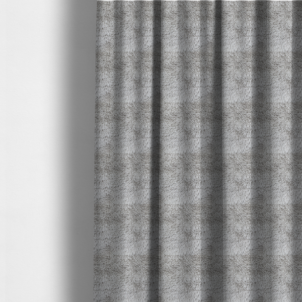 The fabric used to create these made-to-measure curtains is a cool-toned, light silver-grey high-pile faux fur fabric. It has a dense, plush texture characterized by soft, tousled fibres that create a cosy, shag-like appearance.
