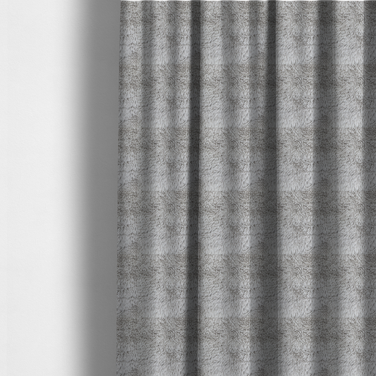 The fabric used to create these made-to-measure curtains is a cool-toned, light silver-grey high-pile faux fur fabric. It has a dense, plush texture characterized by soft, tousled fibres that create a cosy, shag-like appearance.