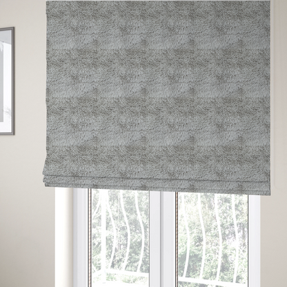 The fabric used to create these Roman blinds is a cool-toned, light silver-grey high-pile faux fur fabric. It has a dense, plush texture characterized by soft, tousled fibres that create a cosy, shag-like appearance.