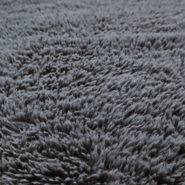 A dark charcoal-grey, high-pile faux fur fabric. It displays a dense, luxurious texture with soft, slightly tousled fibres that create a cosy and sophisticated shag-like appearance.