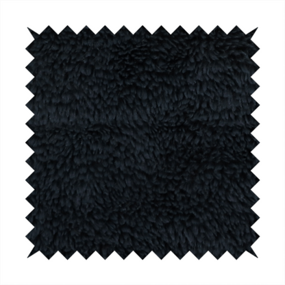a solid black, high-pile faux fur fabric. It displays a dense, luxurious texture with soft, tousled fibres that create a cosy, sophisticated, and uniform shag-like appearance.