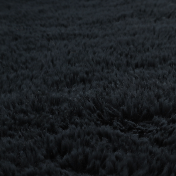a solid black, high-pile faux fur fabric. It displays a dense, luxurious texture with soft, tousled fibres that create a cosy, sophisticated, and uniform shag-like appearance.