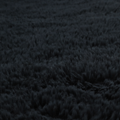 a solid black, high-pile faux fur fabric. It displays a dense, luxurious texture with soft, tousled fibres that create a cosy, sophisticated, and uniform shag-like appearance.