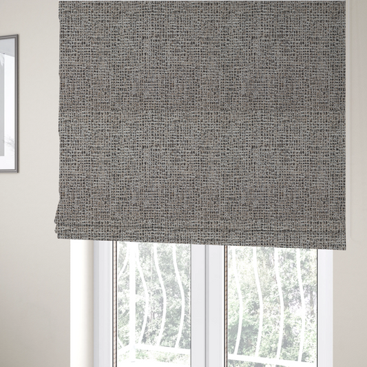 The fabric used to create these Roman blinds is a textured, woven fabric featuring a complex pattern of beige, black, and white threads, creating a speckled and mottled appearance.