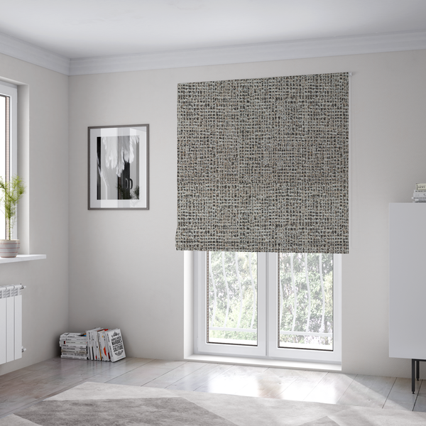The fabric used to create these Roman blinds is a textured, woven fabric featuring a complex pattern of beige, black, and white threads, creating a speckled and mottled appearance.