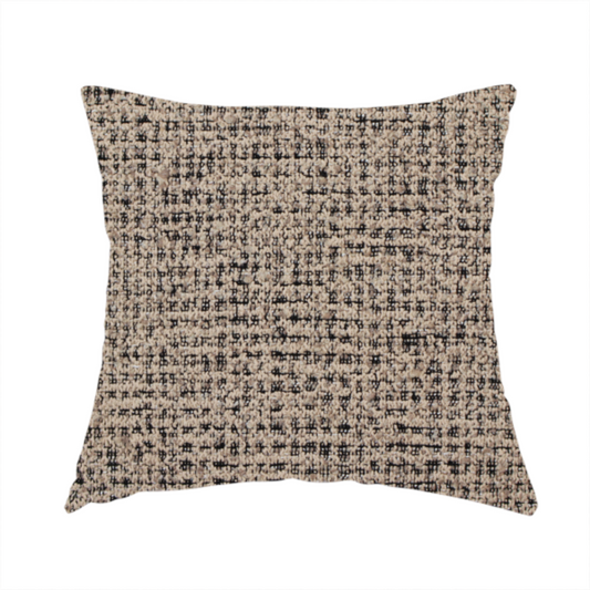 The fabric used to create this handmade cushion is a textured, woven fabric featuring a complex pattern of beige, black, and white threads, creating a speckled and mottled appearance.