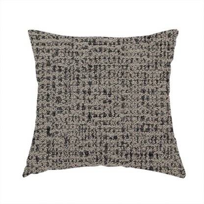 The fabric used to create this handmade cushion is a textured, woven fabric featuring a complex pattern of beige, black, and white threads, creating a speckled and mottled appearance.