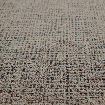 A textured, woven fabric featuring a complex pattern of beige, black, and white threads, creating a speckled and mottled appearance.