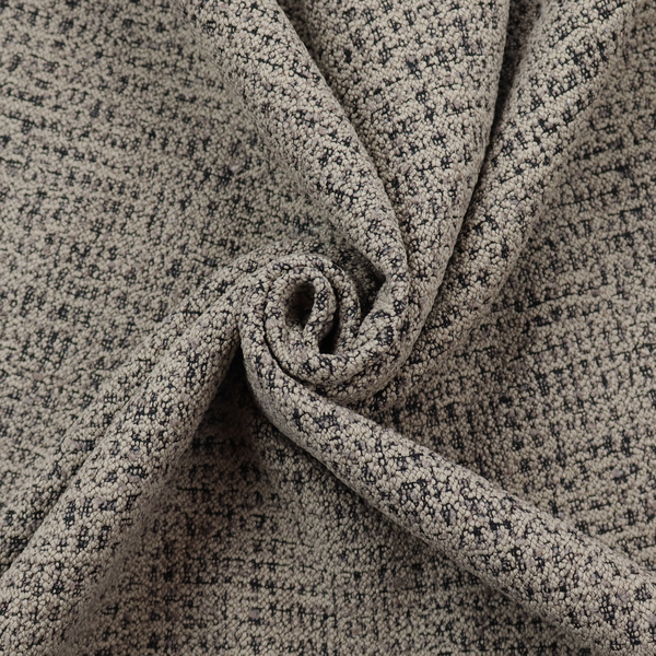 A textured, woven fabric featuring a complex pattern of beige, black, and white threads, creating a speckled and mottled appearance.