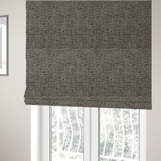 The fabric used to create these Roman blinds is a textured, woven fabric featuring a complex pattern of beige, black, and white threads, creating a speckled and mottled appearance.