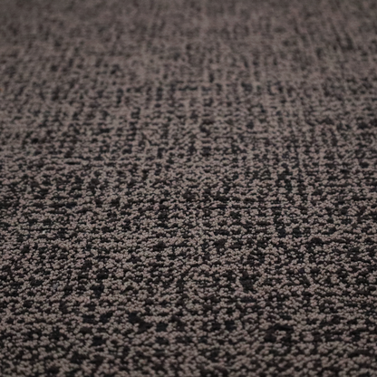 A textured, woven fabric featuring a complex pattern of dark brown, black, and beige threads, creating a speckled and mottled appearance.