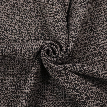A textured, woven fabric featuring a complex pattern of dark brown, black, and beige threads, creating a speckled and mottled appearance.