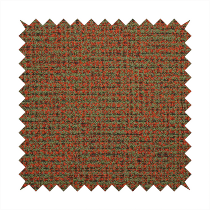 A textured, woven fabric featuring a complex pattern of red, green, and dark threads, creating a speckled and mottled appearance.