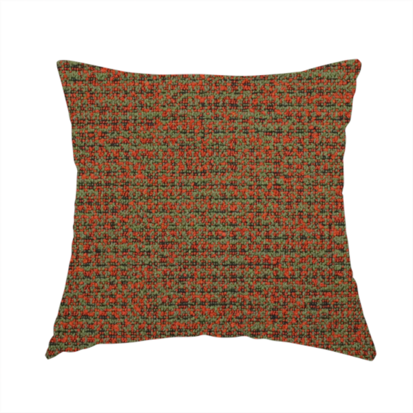 The fabric used to create this handmade cushion is a textured, woven fabric featuring a complex pattern of red, green, and dark threads, creating a speckled and mottled appearance.