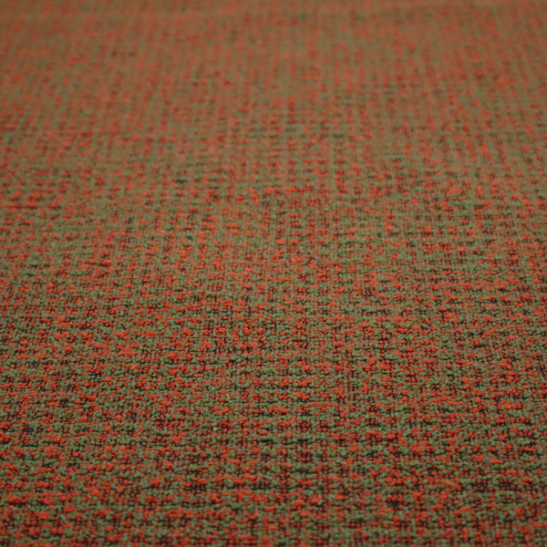 A textured, woven fabric featuring a complex pattern of red, green, and dark threads, creating a speckled and mottled appearance.