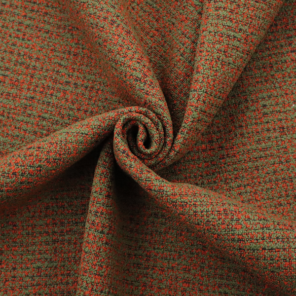 A textured, woven fabric featuring a complex pattern of red, green, and dark threads, creating a speckled and mottled appearance.