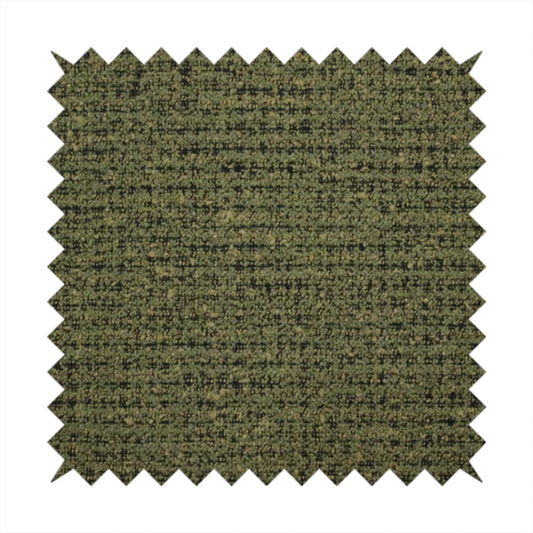 A textured, woven fabric featuring a complex pattern of green, dark, and beige threads, creating a speckled and mottled appearance.