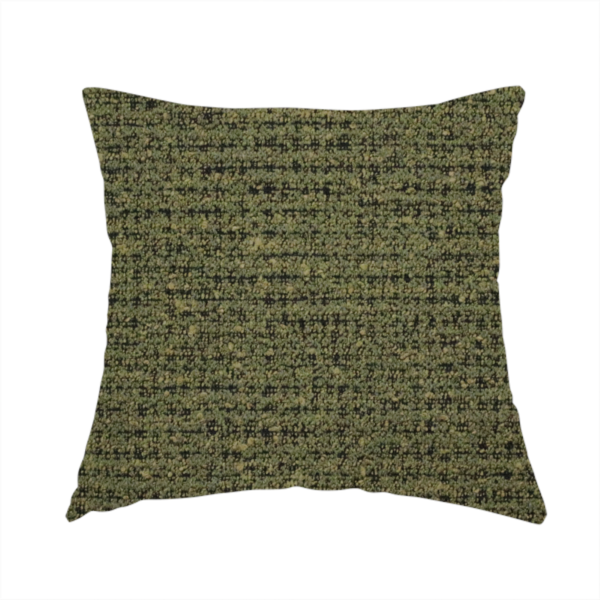 The fabric used to create this handmade cushion is a textured, woven fabric featuring a complex pattern of green, dark, and beige threads, creating a speckled and mottled appearance.