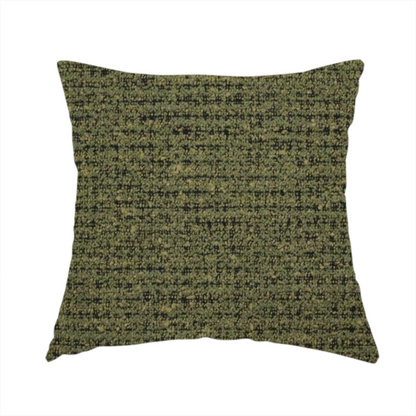 The fabric used to create this handmade cushion is a textured, woven fabric featuring a complex pattern of green, dark, and beige threads, creating a speckled and mottled appearance.