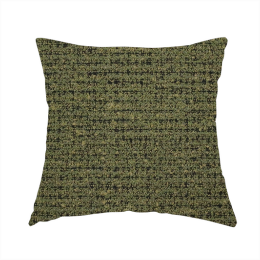 The fabric used to create this handmade cushion is a textured, woven fabric featuring a complex pattern of green, dark, and beige threads, creating a speckled and mottled appearance.