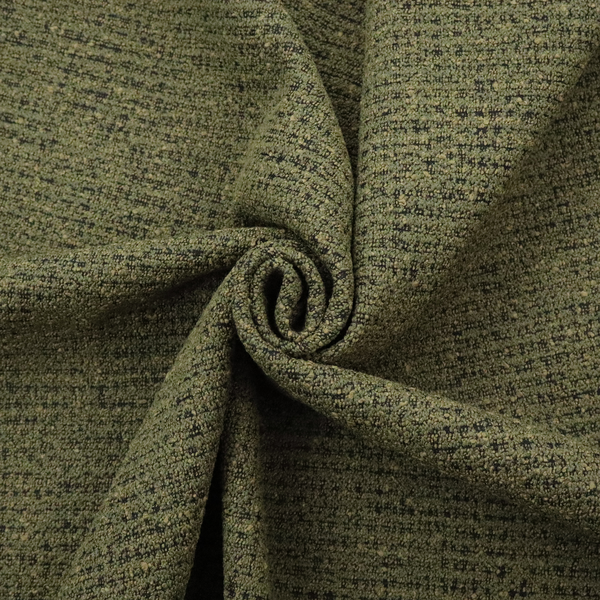 A textured, woven fabric featuring a complex pattern of green, dark, and beige threads, creating a speckled and mottled appearance.