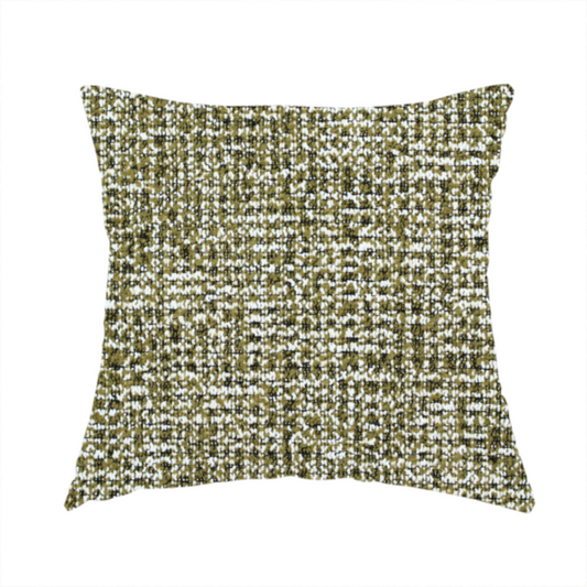 The fabric used to create this handmade cushion is a textured, woven fabric featuring a complex pattern of green, dark, and white threads, creating a speckled and mottled appearance.