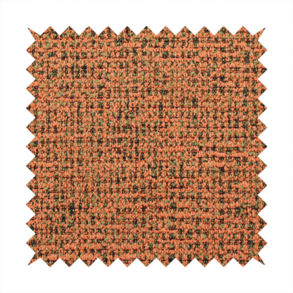 A textured, woven fabric featuring a complex pattern of orange, green, and dark threads, creating a speckled and mottled appearance.