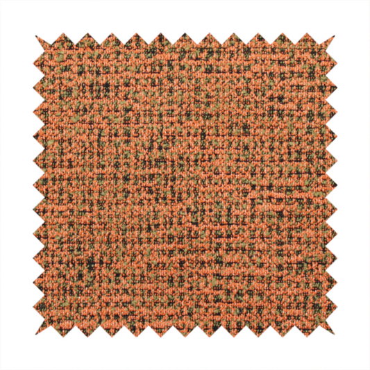 A textured, woven fabric featuring a complex pattern of orange, green, and dark threads, creating a speckled and mottled appearance.