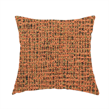 The fabric used to create this handmade cushion is a textured, woven fabric featuring a complex pattern of orange, green, and dark threads, creating a speckled and mottled appearance.