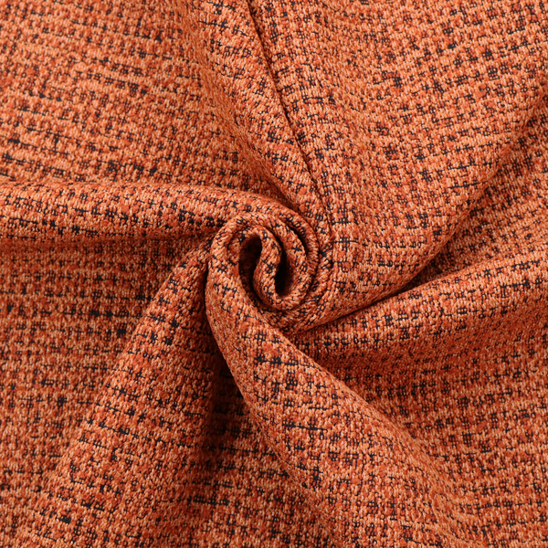 A textured, woven fabric featuring a complex pattern of orange, dark, and beige threads, creating a speckled and mottled appearance.