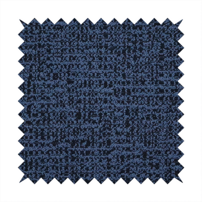 A textured, woven fabric featuring a complex pattern of blue, dark, and navy threads, creating a speckled and mottled appearance.