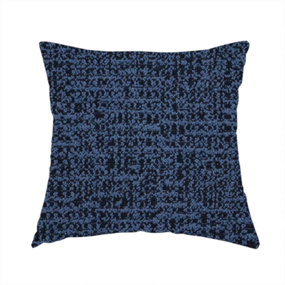 The fabric used to create this handmade cushion is a textured, woven fabric featuring a complex pattern of blue, dark, and navy threads, creating a speckled and mottled appearance.