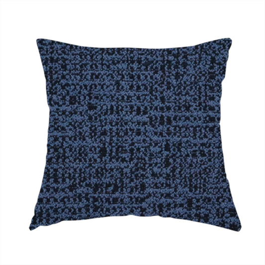 The fabric used to create this handmade cushion is a textured, woven fabric featuring a complex pattern of blue, dark, and navy threads, creating a speckled and mottled appearance.