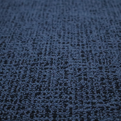 A textured, woven fabric featuring a complex pattern of blue, dark, and navy threads, creating a speckled and mottled appearance.