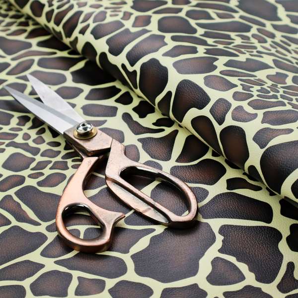A seamless, repeating fabric pattern featuring a brown and cream giraffe print with a textured, leather-like finish on the dark spots.