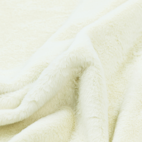 A cream-colored faux fur. The material features a thick, plush pile with a soft sheen, showing a warm ivory tint compared to pure white.