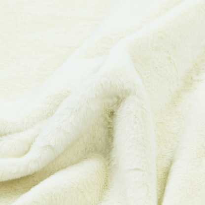 A cream-colored faux fur. The material features a thick, plush pile with a soft sheen, showing a warm ivory tint compared to pure white.