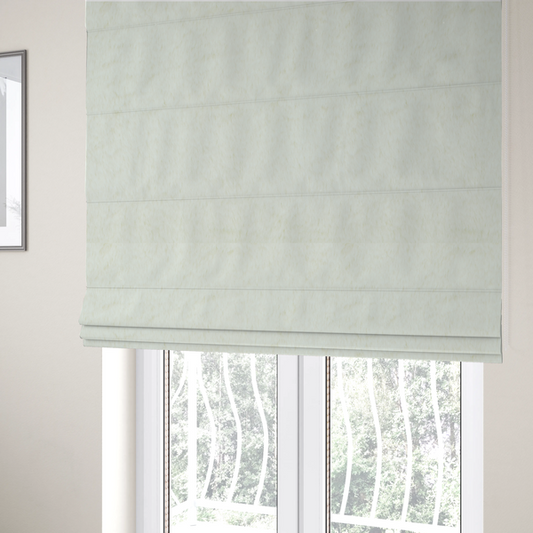 The fabric used to create these Roman blinds is a cream-colored faux fur. The material features a thick, plush pile with a soft sheen, showing a warm ivory tint compared to pure white.
