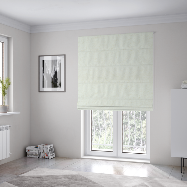 The fabric used to create these Roman blinds is a cream-colored faux fur. The material features a thick, plush pile with a soft sheen, showing a warm ivory tint compared to pure white.
