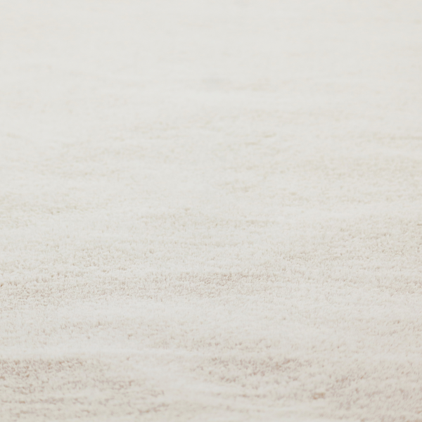 A plush faux fur fabric in a pale oatmeal or light greige shade. The material has a dense, short-pile texture that appears incredibly soft and velvety.