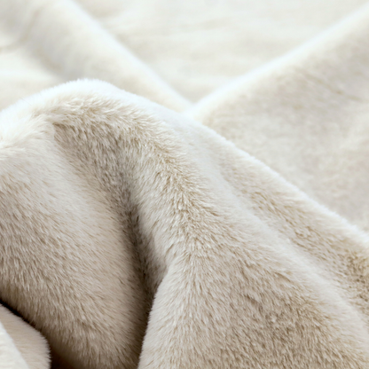 A plush faux fur fabric in a pale oatmeal or light greige shade. The material has a dense, short-pile texture that appears incredibly soft and velvety.
