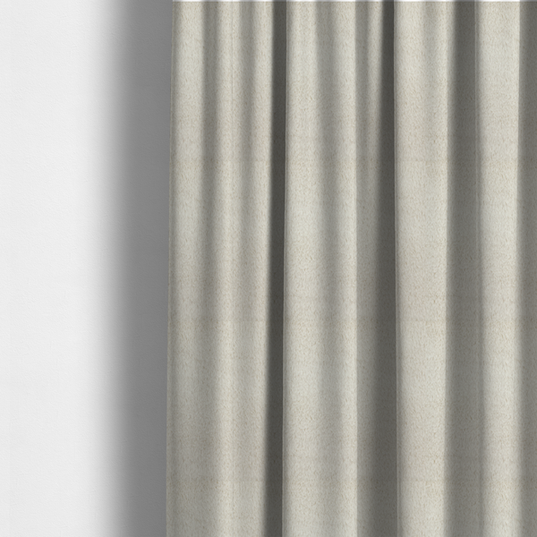 The fabric used to create these made-to-measure curtains is a plush faux fur fabric in a pale oatmeal or light greige shade. The material has a dense, short-pile texture that appears incredibly soft and velvety.