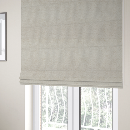 The fabric used to create these Roman blinds is a plush faux fur fabric in a pale oatmeal or light greige shade. The material has a dense, short-pile texture that appears incredibly soft and velvety.