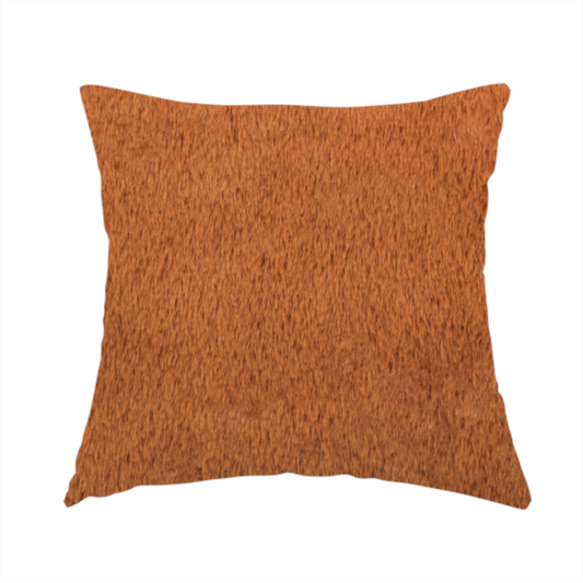 The fabric used to create these handmade cushions is a plush faux fur fabric in a deep, vibrant burnt orange or copper hue. The material displays a dense, short-pile texture that creates a rich, velvet-like appearance. The fibres have a soft, uniform grain that catches the light to reveal warm, glowing undertones, giving the fabric a luxurious sense of depth.