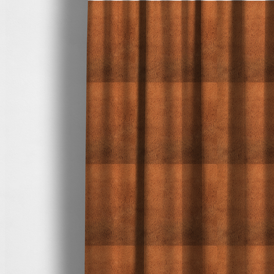 The fabric used to create these made-to-measure curtains is a plush faux fur fabric in a deep, vibrant burnt orange or copper hue. The material displays a dense, short-pile texture that creates a rich, velvet-like appearance. The fibres have a soft, uniform grain that catches the light to reveal warm, glowing undertones, giving the fabric a luxurious sense of depth.