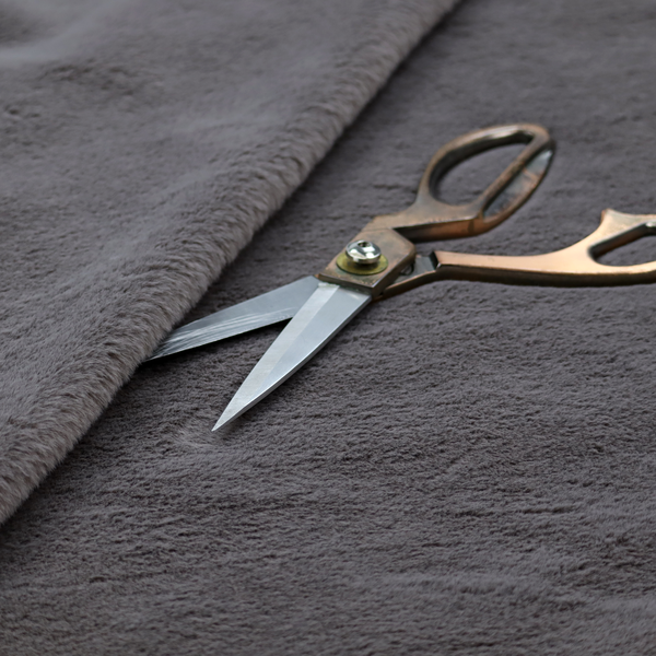 A plush faux fur fabric in a deep charcoal or slate grey. The material has a dense, short-pile texture that creates a soft, uniform surface with a subtle velvety sheen. The cool-toned grey fibres are tightly packed, providing a rich matte finish that catches the light to reveal fine depth and a luxurious hand-feel.