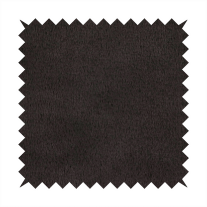 A luxurious faux fur fabric in a deep off-black or charcoal noir shade. The material has an exceptionally dense, short-pile texture that creates a rich, velvet-like surface. The dark fibres catch the light to reveal subtle, cool-toned depth, giving the fabric a sophisticated matte finish.