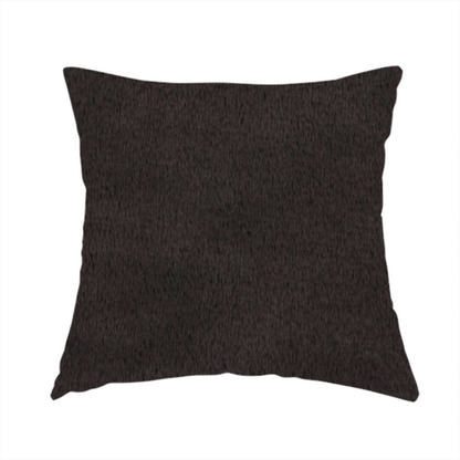 The fabric used to create this handmade cushion is a luxurious faux fur fabric in a deep off-black or charcoal noir shade. The material has an exceptionally dense, short-pile texture that creates a rich, velvet-like surface. The dark fibres catch the light to reveal subtle, cool-toned depth, giving the fabric a sophisticated matte finish.